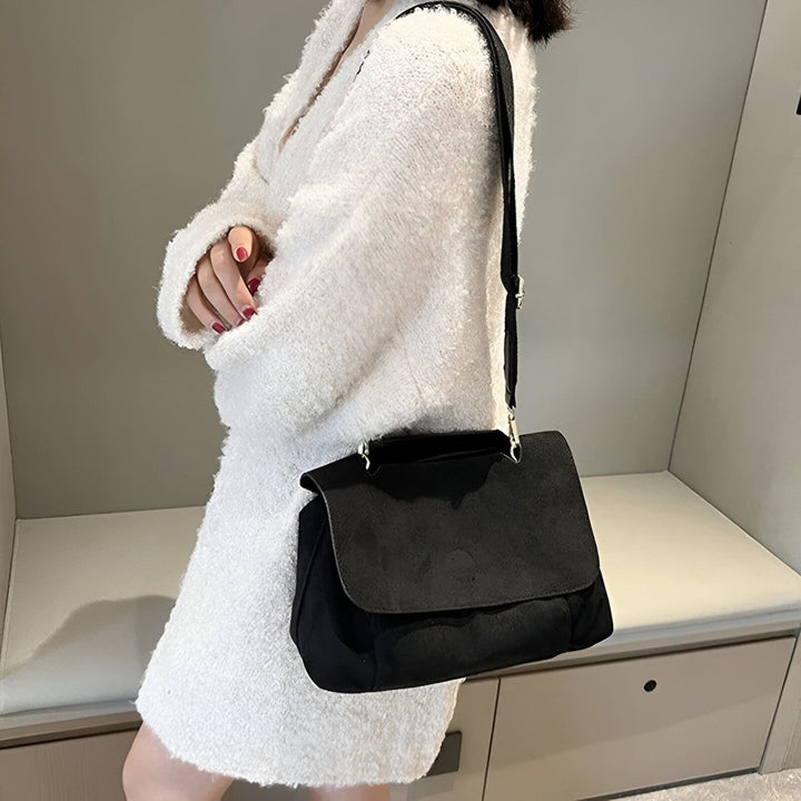 Sac noir à bandoulière avec rabat porté par une personne en manteau blanc duveteux., 46193886396640,46193886429408