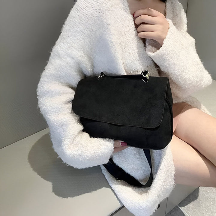 Femme avec un sac épaule noir en daim et un cardigan blanc doux., 46193886396640,46193886429408