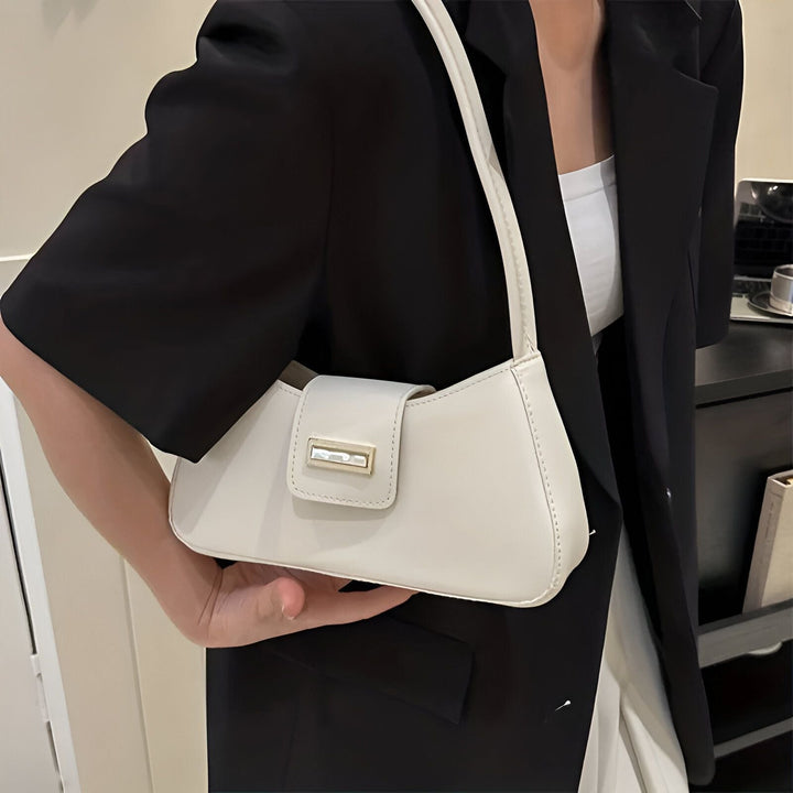 Une femme tenant un petit sac à main blanc et portant une veste noire., 46193943445728,46193943478496,46193943511264,46193943544032,46193943576800,46193943609568
