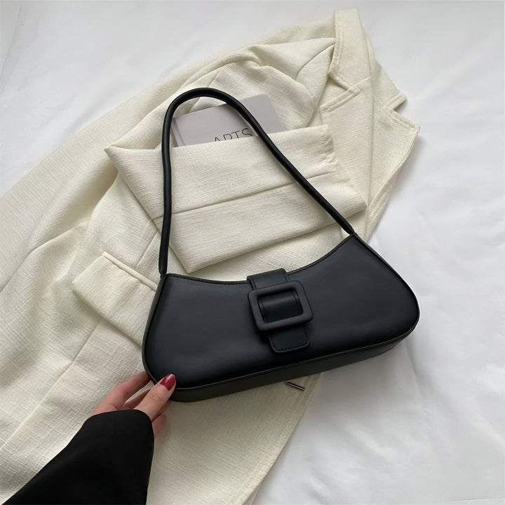 Sac baguette noir avec boucle, posé sur un blazer clair., 46193943707872,46193943740640,46193943773408,46193943806176