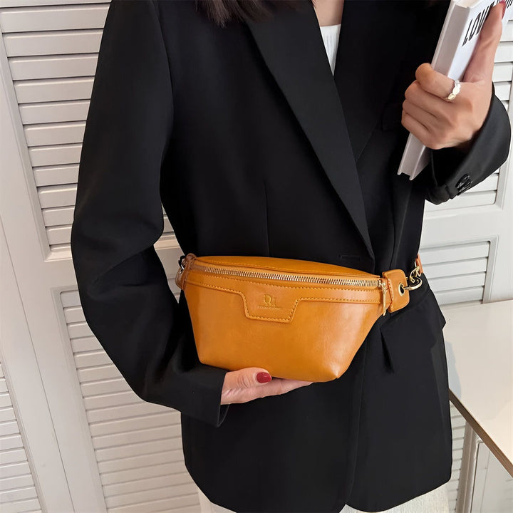Sac banane en cuir camel porté avec un blazer noir., 46194025332960,46194025365728,46194025398496,46194025431264,46194025464032