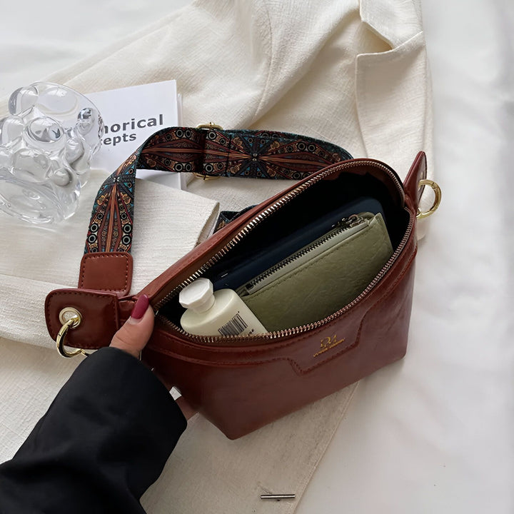 Sac banane en cuir marron avec sangle à motifs colorés, ouvert montrant contenu., 46194025332960,46194025365728,46194025398496,46194025431264,46194025464032