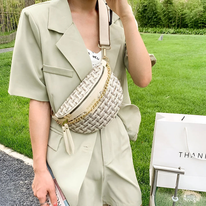 Sac banane tissé blanc et beige avec chaîne dorée, porté sur un ensemble short et veste vert pâle., 46194025005280,46194025038048,46194025070816,46194025103584