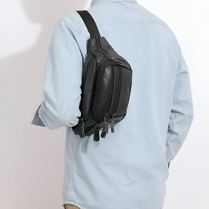 Sac banane en cuir noir avec multiples poches zippées, porté par un homme., 46194063802592,46194063835360,46194063868128