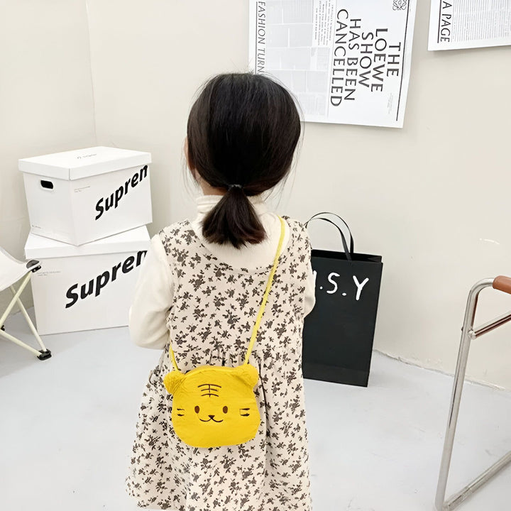 Petite fille avec robe à fleurs et sac jaune en forme de tigre., 46193976475872,46193976508640,46193976541408