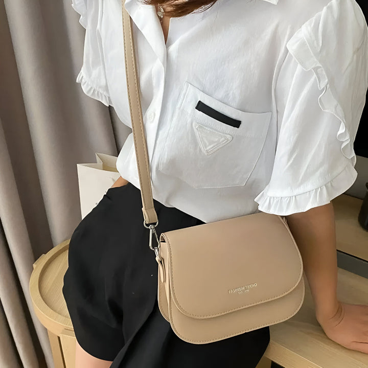 Sac bandoulière beige porté par une personne en chemise blanche et short noir., 46193966907616,46193966940384,46193966973152,46193967005920,46193967038688