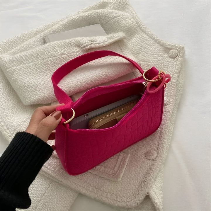 Sac bandoulière rose fuchsia texturé ouvert tenu par une main., 46193938596064,46193938628832,46193938661600,46193938694368