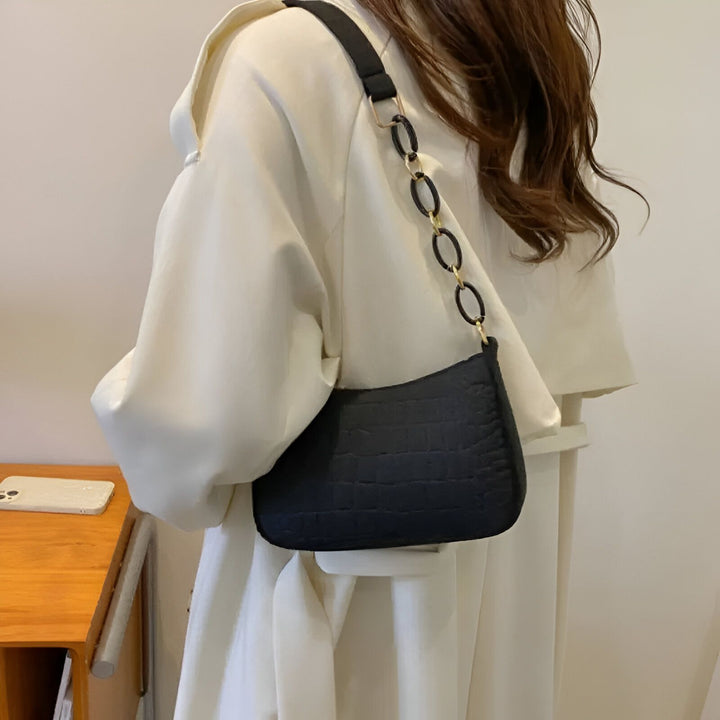Sac à épaule noir texturé effet crocodile avec anse chaîne dorée, porté avec une veste claire., 46193938596064,46193938628832,46193938661600,46193938694368