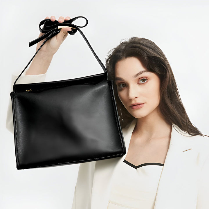Sac à main noir en cuir tenu par une femme, 46193866965216