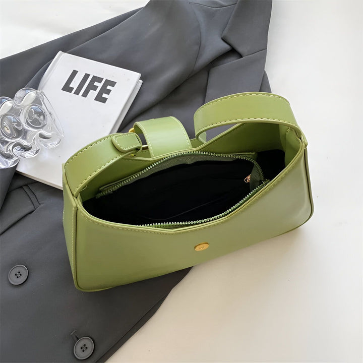 Sac à main vert ouvert, posé sur un blazer gris., 46193872797920,46193872830688,46193872863456,46193872896224