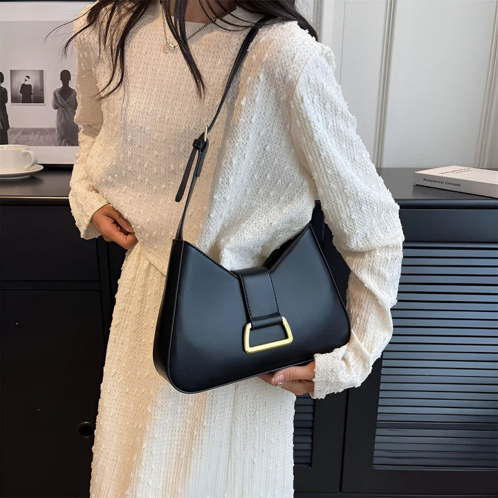 Femme tenant un sac bandoulière noir élégant avec boucle dorée., 46193872797920,46193872830688,46193872863456,46193872896224