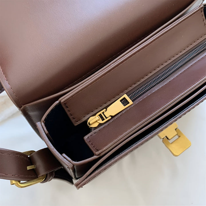 Détail d'un sac en cuir marron, fermeture éclair noire avec tirette dorée, boucle dorée., 46194027069664,46194027102432,46194027135200,46194027167968