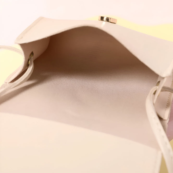 Intérieur d'un sac beige clair ouvert avec détail doré sur le rabat., 46193984110816,46193984176352,46193984209120,46193984241888