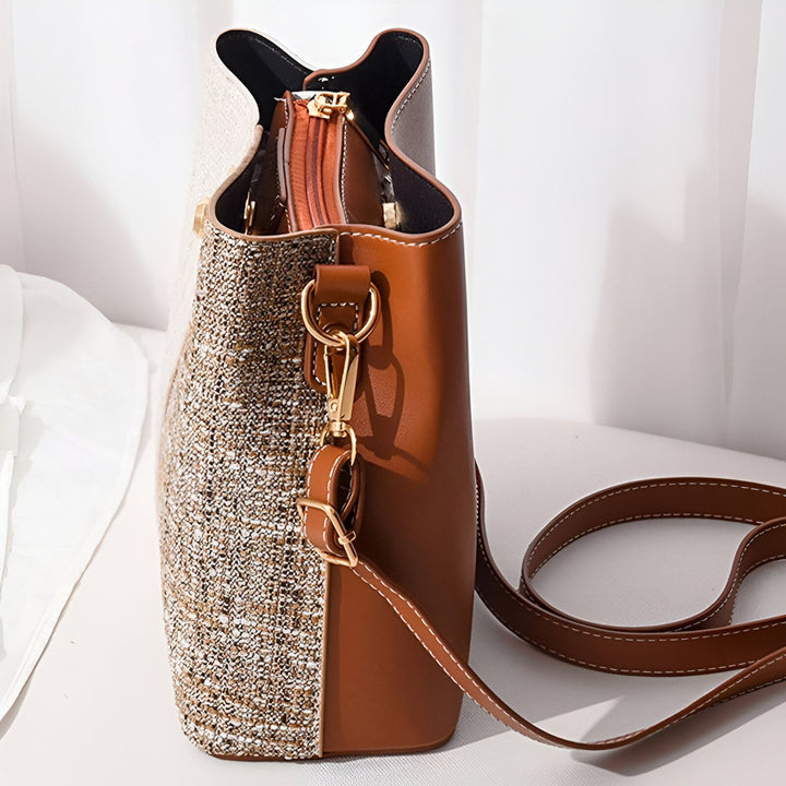 Sac à main marron et beige texturé avec bandoulière et fermeture éclair visible sur une table., 46193874469088,46193874501856,46193874534624,46193874567392