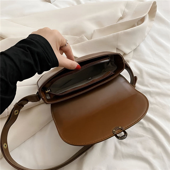 Main ouvrant un petit sac bandoulière en cuir marron, intérieur avec poche zippée., 46194026283232,46194026316000,46194026348768,46194026381536