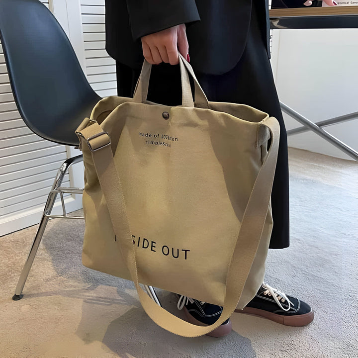 Personne tenant un grand sac tote bag en toile beige avec texte "INSIDE OUT"., 46193896751328,46193896784096