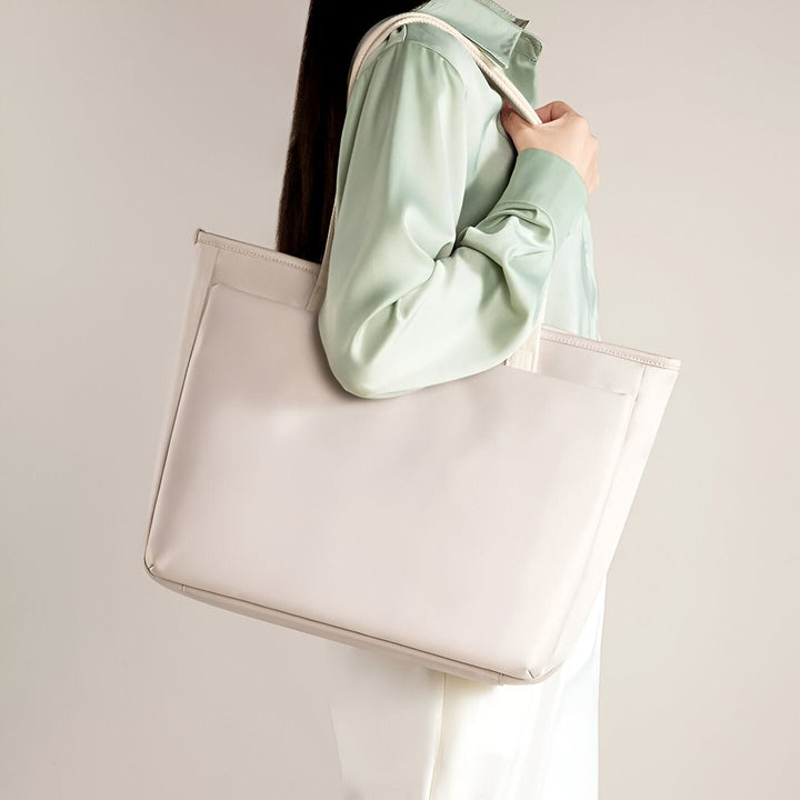 Femme portant un grand sac fourre-tout clair sur l'épaule., 46193954128096,46193954160864,46193954193632