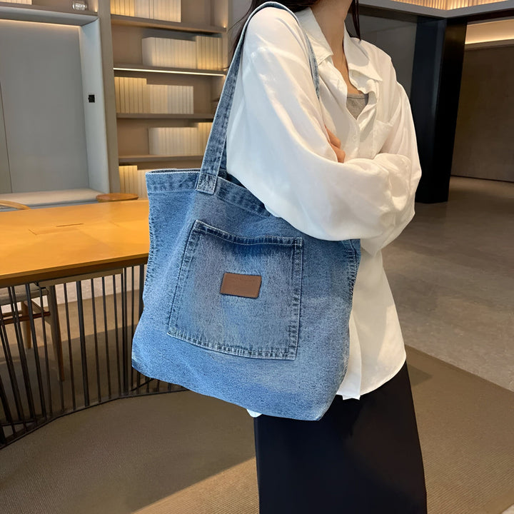 Femme avec un grand sac cabas en jean bleu porté à l'épaule., 46193991942368,46193991975136