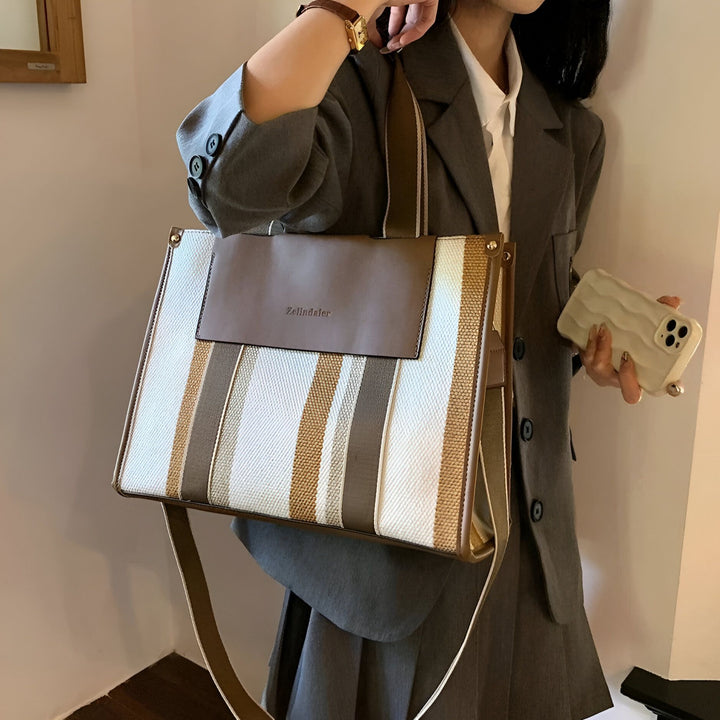Sac cabas Zelindaler rayé blanc, marron, taupe, rabat, porté par modèle en costume gris., 46193896030432,46193896063200,46193896095968,46193896128736