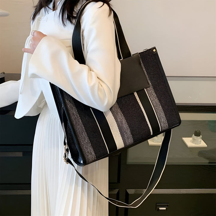 Sac cabas rayé noir, gris et blanc porté par une femme., 46193896030432,46193896063200,46193896095968,46193896128736
