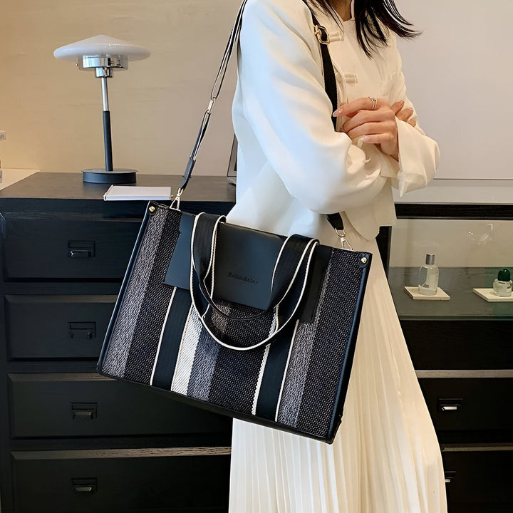 Femme tenant un sac fourre-tout structuré rayé noir et blanc., 46193896030432,46193896063200,46193896095968,46193896128736