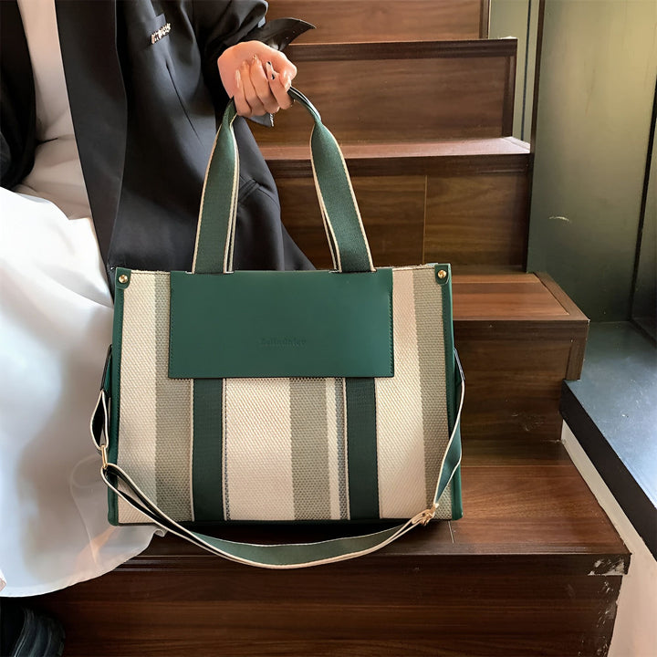Sac cabas rayé vert et écru avec rabat vert, tenu sur des marches., 46193896030432,46193896063200,46193896095968,46193896128736