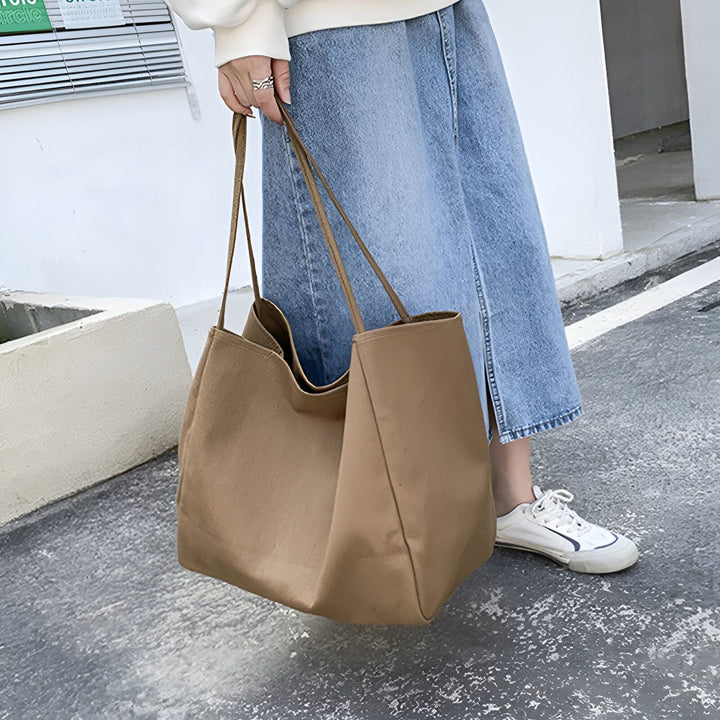 Sac cabas camel en toile porté avec une jupe en jean et des baskets., 46193893048544,46193893081312