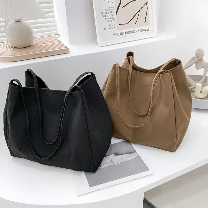 Deux sacs à main cabas, noir et marron, sur une étagère., 46193893048544,46193893081312