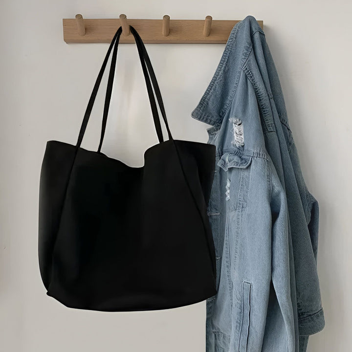 Sac cabas noir et veste en jean bleue accrochés à un porte-manteau en bois., 46193893048544,46193893081312