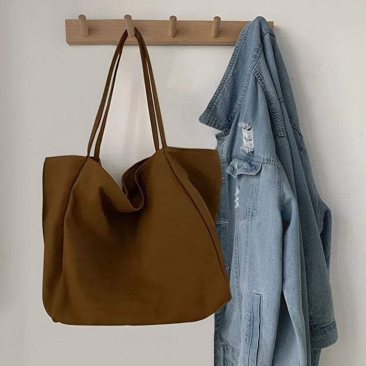 Sac cabas marron et veste en jean bleue accrochés., 46193893048544,46193893081312
