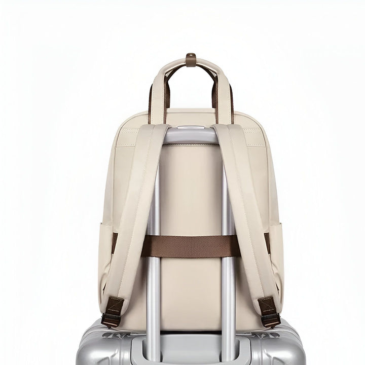 Sac à dos beige avec sangle de fixation posé sur la poignée télescopique d'une valise., 46193875878112,46193875910880,46193875943648,46193875976416