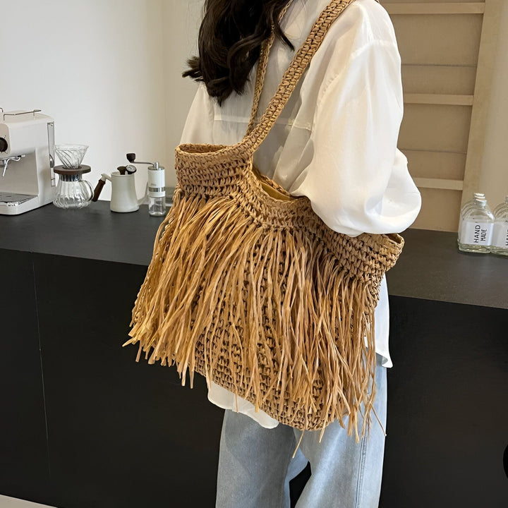 Sac cabas en paille naturelle à franges porté par une femme., 46193922965728,46193922998496