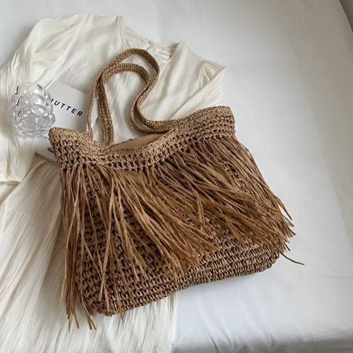 Sac cabas en paille avec franges posé sur une robe blanche, 46193922965728,46193922998496