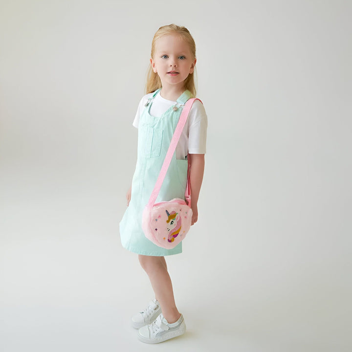 Jeune fille en salopette bleue ciel avec un sac rose licorne en forme de cœur., 46193985749216,46193985781984,46193985814752,46193985847520