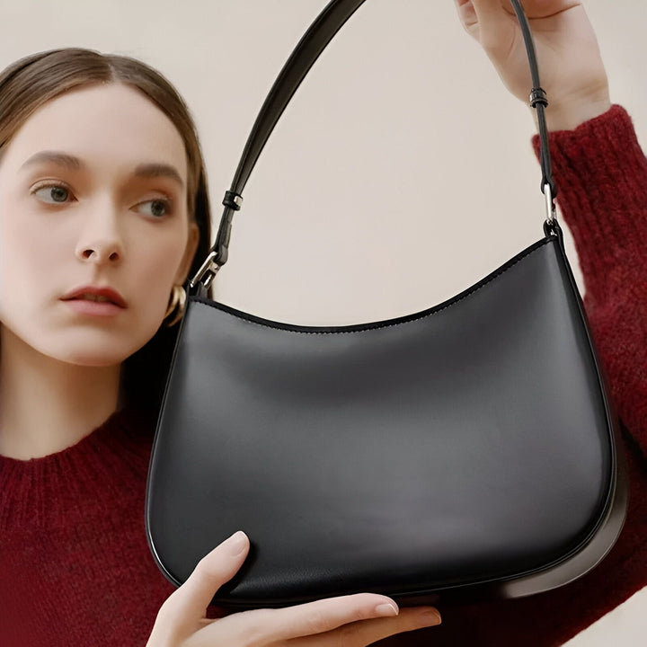 Une femme en pull rouge présentant un sac à bandoulière noir, 46193861034208