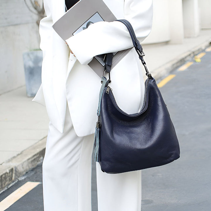 Sac bleu marine en cuir grainé avec pompon porté avec un costume blanc, 46193838129376,46193838162144,46193838194912,46193838227680,46193838260448,46193838293216,46193838325984