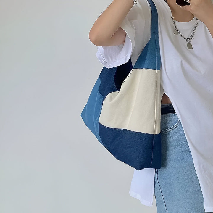 Tote bag patchwork bleu et crème porté par une personne, 46193996628192