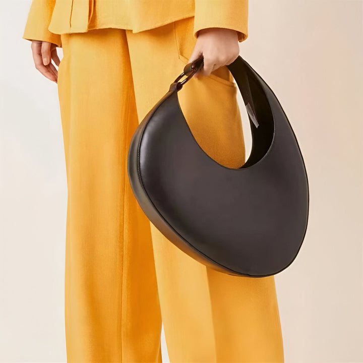 Sac lune en cuir noir porté avec un pantalon jaune vif., 46194017698016,46194017730784,46194017763552