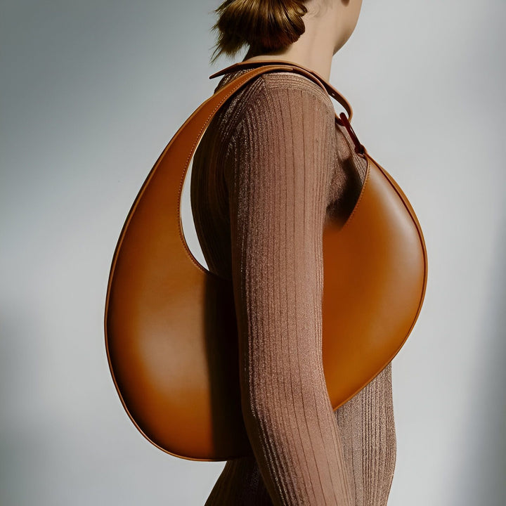 Modèle portant un grand sac marron en forme de lune sur l'épaule., 46194017698016,46194017730784,46194017763552