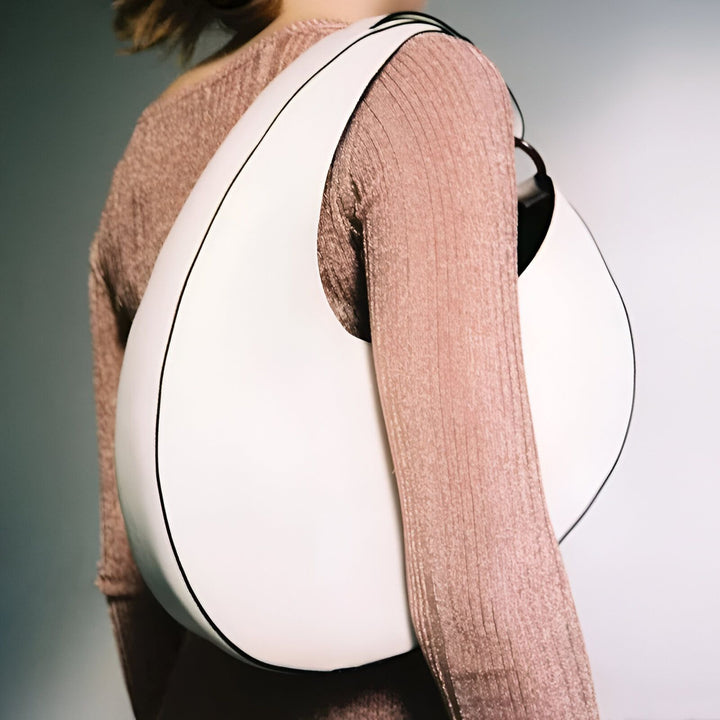 Gros sac blanc en forme de goutte porté à l'épaule sur un haut rose texturé., 46194017698016,46194017730784,46194017763552