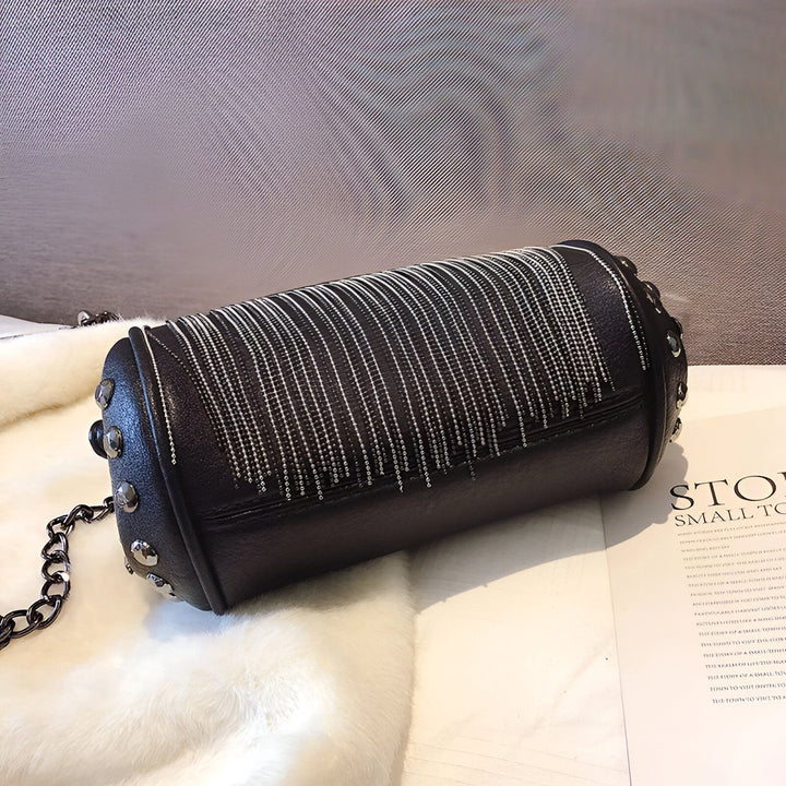 Sac à main noir cylindrique avec clous argentés et chaînes décoratives., 46193948852448