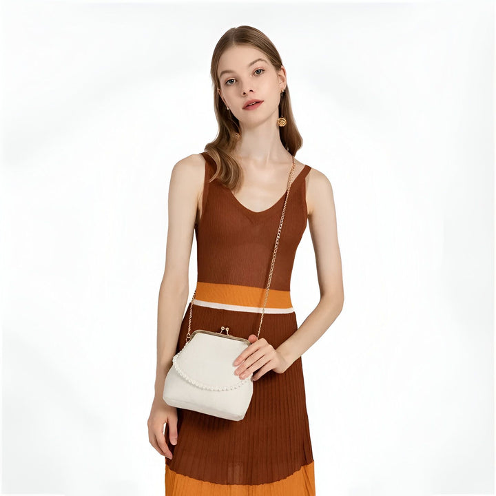 Jeune femme en robe tricotée marron à rayures et sac pochette blanc orné de perles., 46193949081824,46193949114592,46193949147360