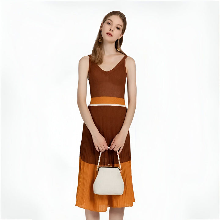 Femme en robe tricotée marron, orange et blanche, tenant un sac blanc avec anse en perles., 46193949081824,46193949114592,46193949147360