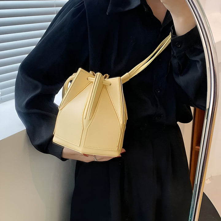 Personne tenant un sac seau jaune pâle structuré., 46194005213408,46194005246176,46194005278944,46194005311712,46194005344480,46194005377248