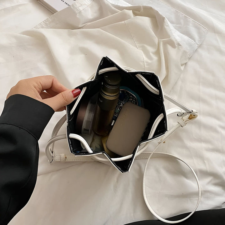 Main ouvrant un petit sac seau blanc rempli d'objets., 46194005213408,46194005246176,46194005278944,46194005311712,46194005344480,46194005377248