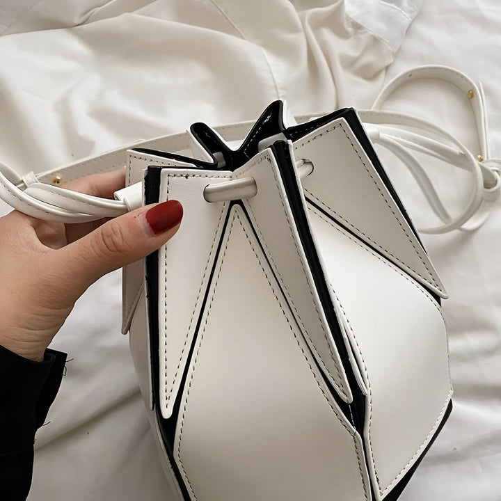 Sac à main géométrique blanc avec bordures noires et détails de couture., 46194005213408,46194005246176,46194005278944,46194005311712,46194005344480,46194005377248