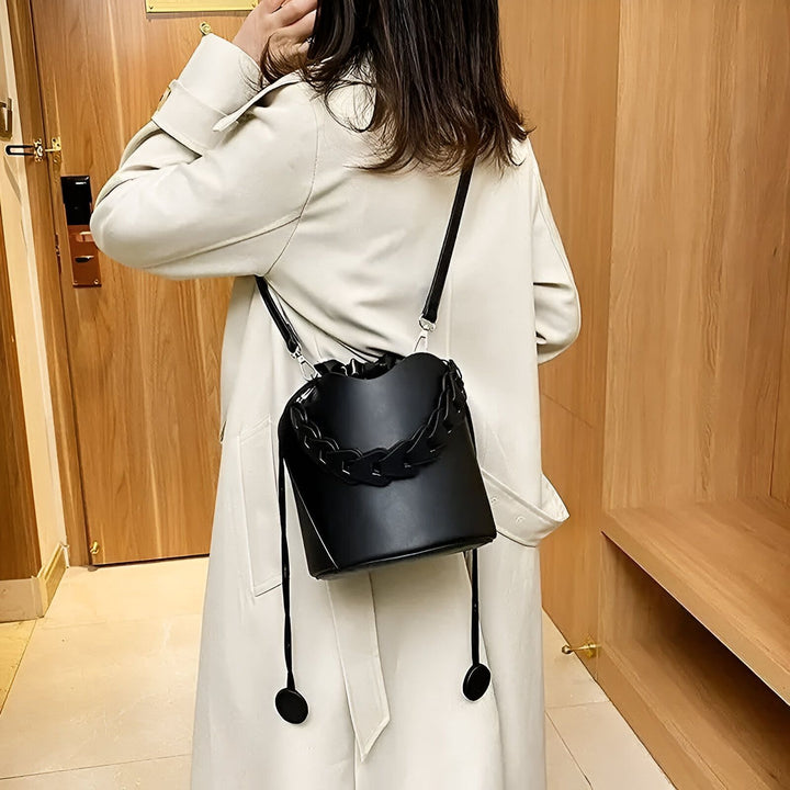 Personne de dos avec trench beige et sac seau noir à chaîne., 46194008850656,46194008883424,46194008916192,46194008948960