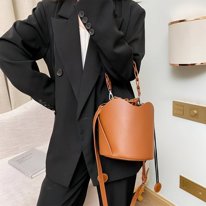 Femme en blazer noir portant un sac seau marron en cuir., 46194008850656,46194008883424,46194008916192,46194008948960