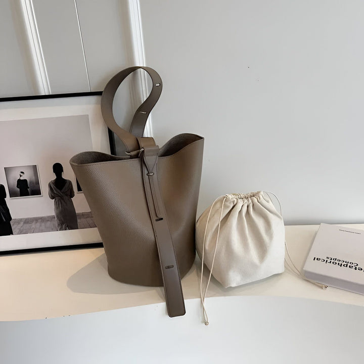 Sac seau en cuir taupe, pochette en tissu beige et livre sur étagère., 46193881710816,46193881743584,46193881776352