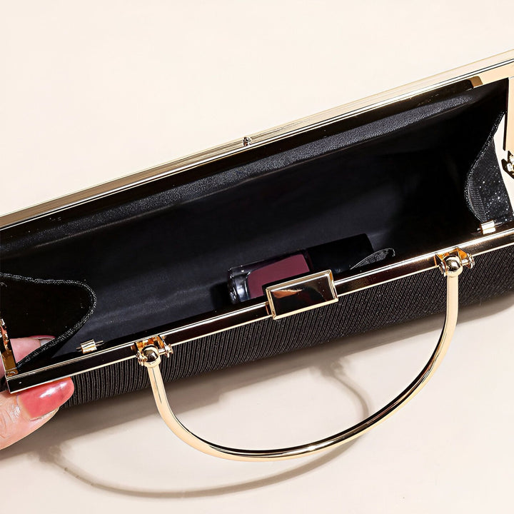 Sac pochette noir ouvert avec garniture dorée, contenant un rouge à lèvres., 46194028019936,46194028052704